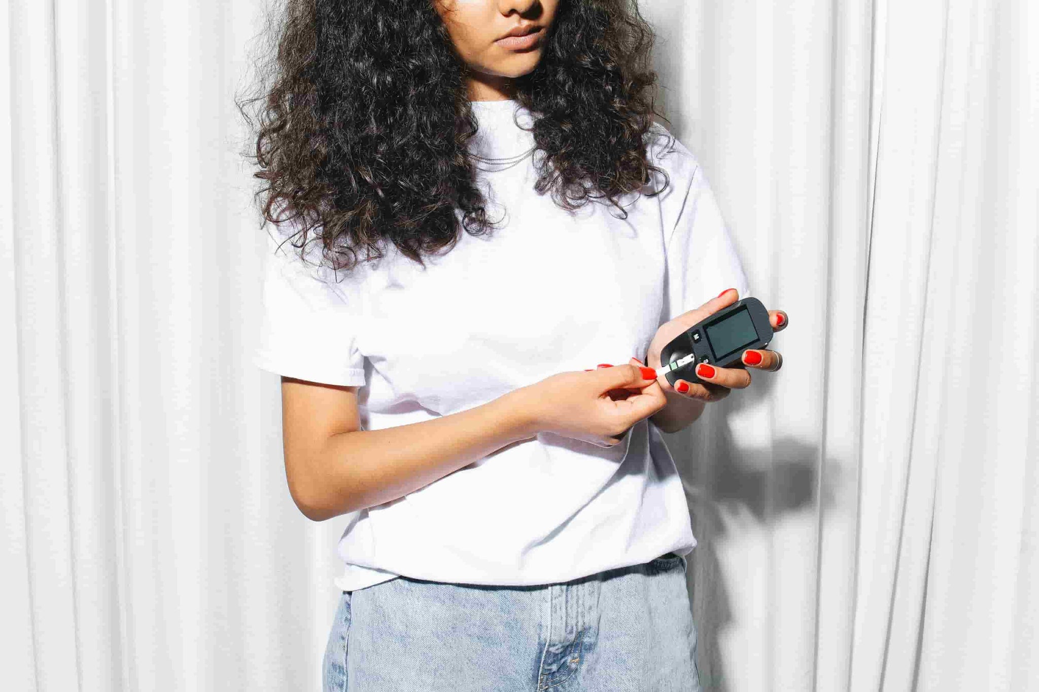 woman checking her blood sugar levels with device