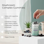 Mushroom complex gummies with a hand picking one, placed on a surface with a blurred background.